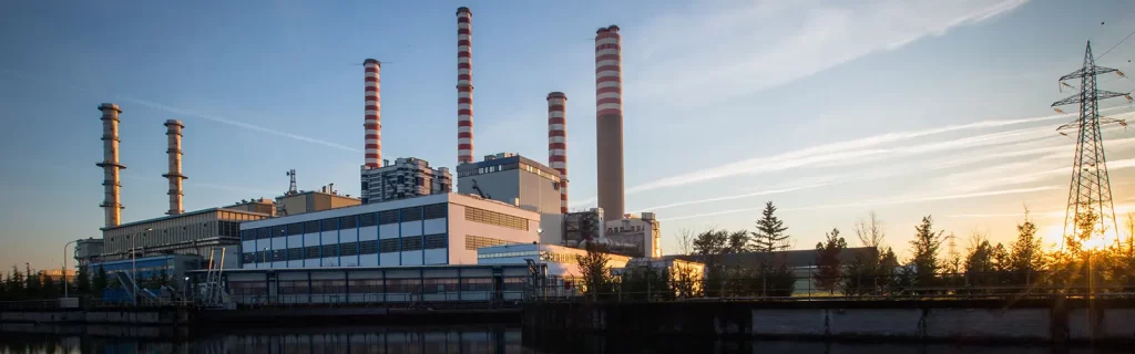 Power plant with smoke stacks at sunset