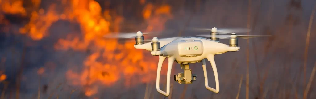A drone flying into a forrest fire area