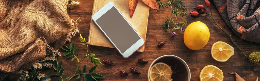 A smartphone on a table with various Thanksgiving elements
